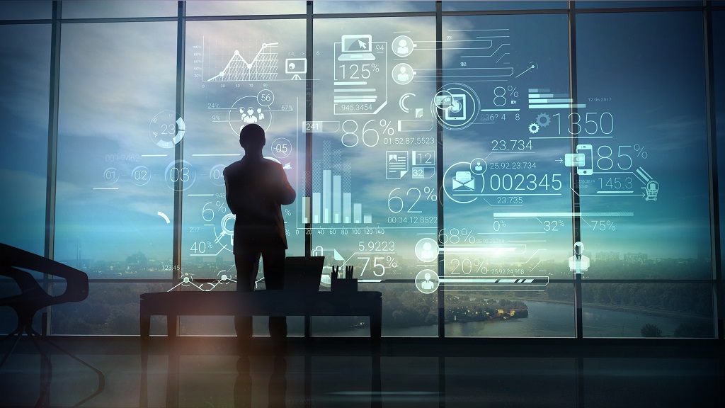 Silhouette of the man in the office and corporate infographic A silhouette of a man stands on the background of large office windows and views a hologram of corporate infographic with work data.